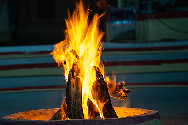 Small log bonfire burning in a pit showing how people keep warm in the freezing temperatures of delh india on the auspicious ocassion of lohri, holi, dussera
