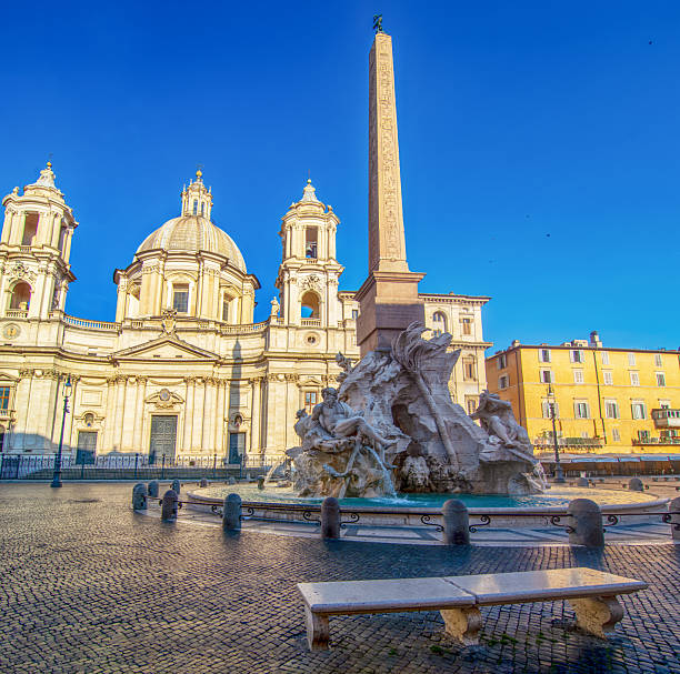 A bright morning view of Piazza Navona with the baroque church of Sant’Agnese in Agone and the obelisk of the Fountain of the Four Rivers in Rome, Italy