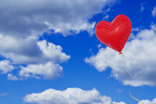 Love And Freedom Concept. Red Heart Shaped Balloon Floating In Blue Sky With White Clouds Background. 3d Rendering
