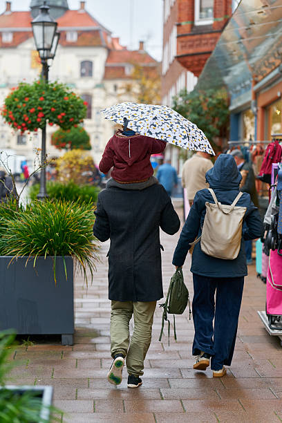 Luneburg, Germany – November 01, 2025: Family walking through downtown Lüneburg, Germany, in the rain