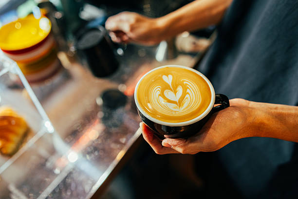 Barista man is preparing latte at coffee shop.