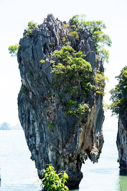 Tall limestone formation rising from the sea at James Bond Island in Phang Nga Bay, Thailand