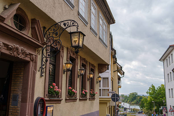 Aschaffenburg, Bavaria, Germany - August 30, 2025: Traditional lanterns hanging outside the restaurant on traditional half-timbered house in a historical city. Classic European street atmosphere and architectural detail.  Half-timbered (Fachwerk in German) houses, German culture and construction traditions