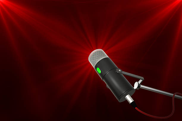 Close up of a podcast microphone on a stand with a red background