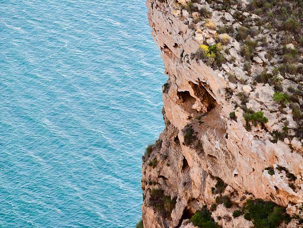 Turquoise Sea Beside Rugged Limestone Cliff, Steep Erosion Patterns, Weathered Rock Faces, Nesting Seabird