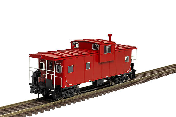 A single red railroad caboose parked on railway track.
