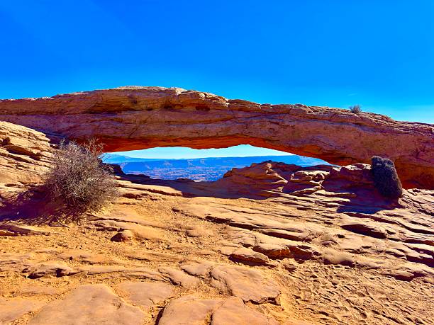 Breathtaking view of the iconic Double Arch rock formation in Arches National Park, Utah. The massive sandstone arches, set against a vibrant blue sky, showcase the natural beauty and geological wonders of this stunning landscape. Ideal for projects related to travel, nature, geology, and outdoor adventure.