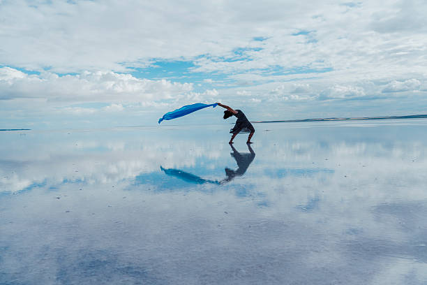 A modern young dancer dancing on the lake in blue tulle.