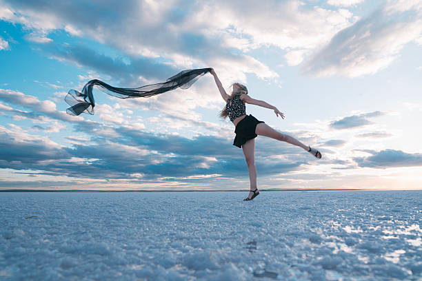 A modern young dancer dancing on the lake in tulle.