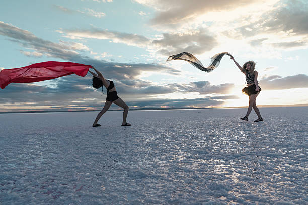 Two modern young dancers dancing on the lake in red tulle.