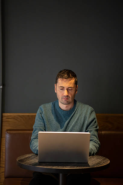 istock Focused mid-adult man working on laptop in a cozy cafe environment. 2257997933