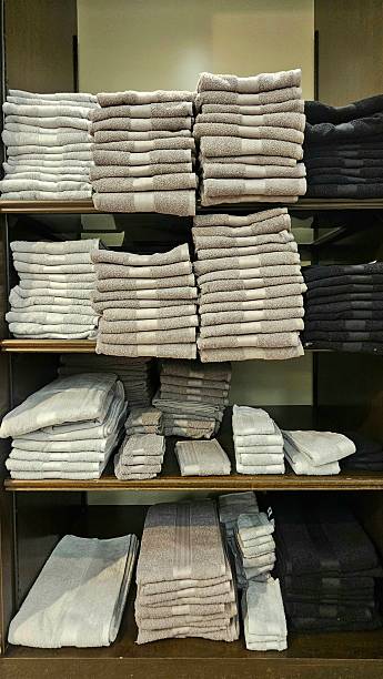 istock Neatly folded towels stacked on shelves 2258007527