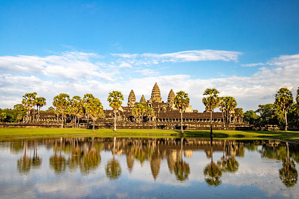 Angkor Wat is the world's largest religious monument, covering 162.6 hectares in Siem Reap Province, Cambodia. Built around 1113-1150 CE by Khmer King Suryavarman II, it was originally a Hindu temple dedicated to Vishnu before becoming Buddhist by the late 12th century. The complex features five lotus-bud towers rising to 65 meters, with approximately 1,200 square meters of bas-relief carvings depicting Hindu epics. Unusually facing west, Angkor Wat means \