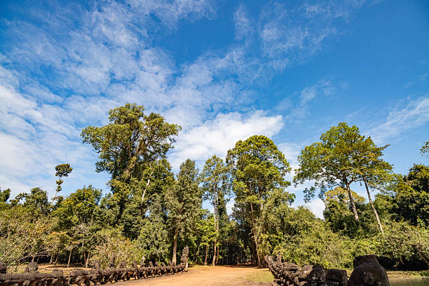 Elaborately carved stone faces at Angkor Thom temple in Cambodia showcase exquisite craftsmanship and cultural history, offering viewers a glimpse into revered Khmer architecture and cultural heritage of ancient times.