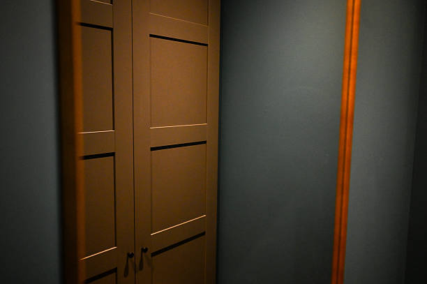Wooden closet doors featuring handles in an interior room with a blue wall