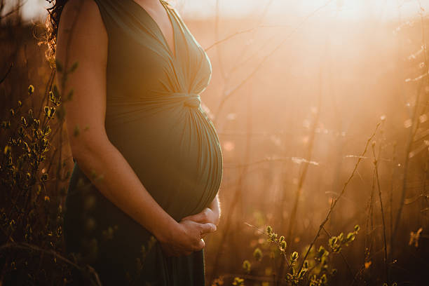 Pregnant woman at sunset with copy space