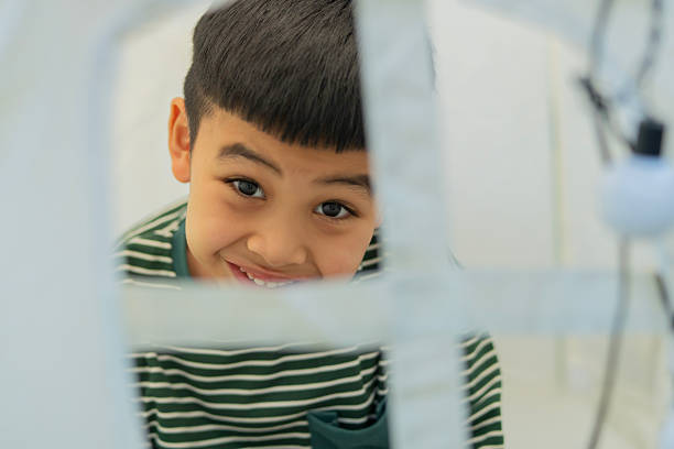 Happy 5 years old little Asian boy sitting in a teepee tent show his smile brightly and make funny faces. Children's room, childhood, games, imagination.