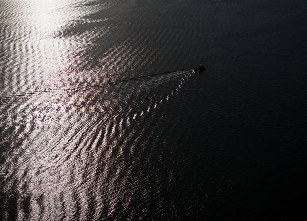 Closeup luxury motorboat anchor and rope with reflection of water and light, side view, copy space, full frame horizontal composition