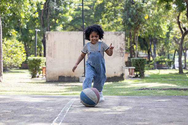 istock Happy Child Playing with Ball in Sunny Park 2258039763