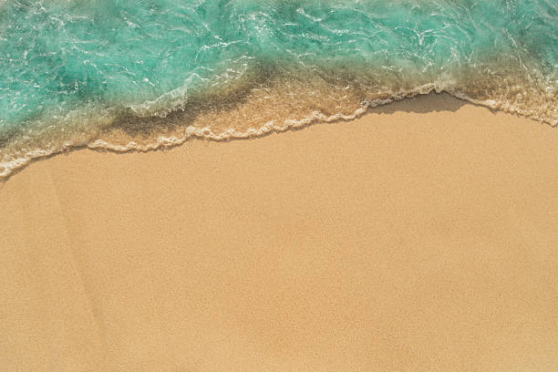 istock beautiful blue wave on  sand beach, closeup, top view 2258047158