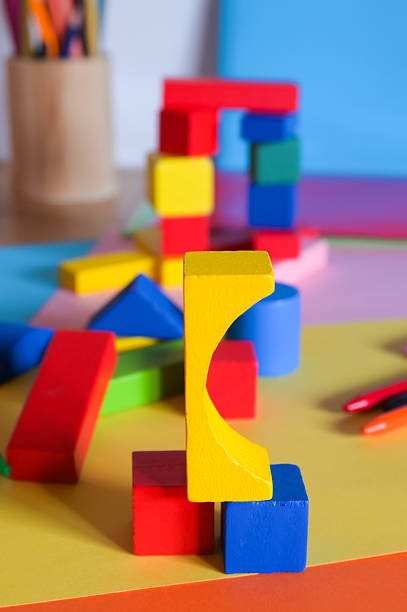 Variously shaped and sized colorful wooden toy blocks assembled and scattered on a table, stimulating creativity, learning, and early childhood development through play
