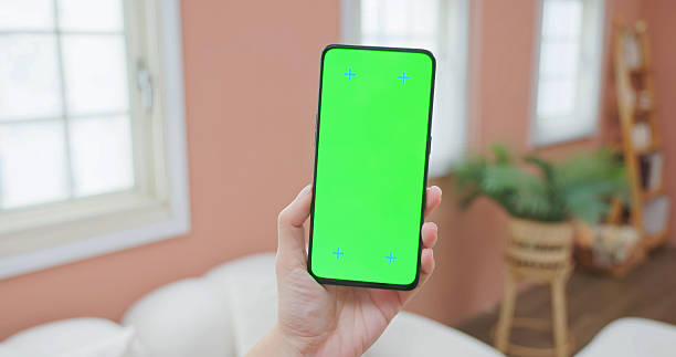 Closeup view of asian people hold a straightly mobile phone show green screen in the room
