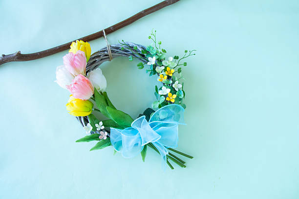 Three Color tulip and bouvardia wreath with pale blue background.