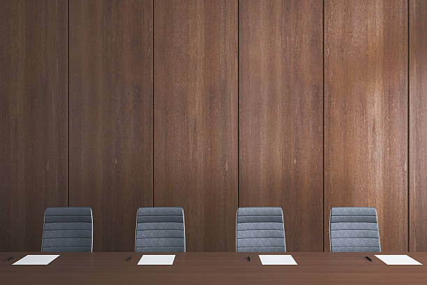 Empty modern conference room with dark wood table, gray chairs, papers and pens on desk, wooden background. 3D Rendering