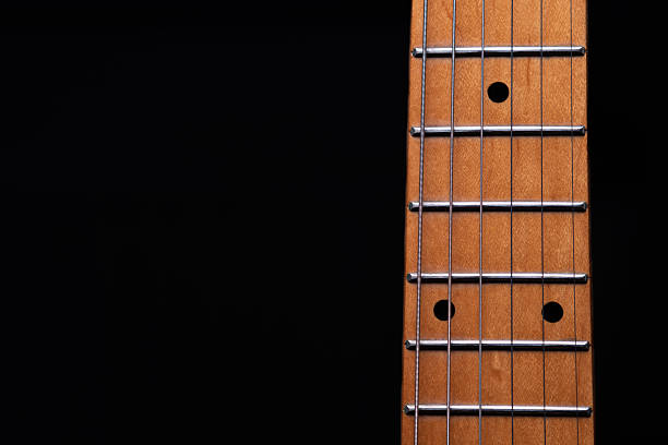 Close up of neck and frets of an electric guitar.