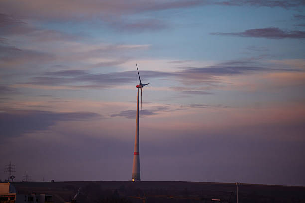 A single wind turbine standing against a colorful evening sky, representing renewable energy, sustainability, clean power, and environmental technology.