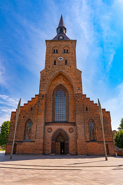 Saint Knuds Kirke cathedral in Odense Denmark showing gothic red brick facade and tower under blue sky