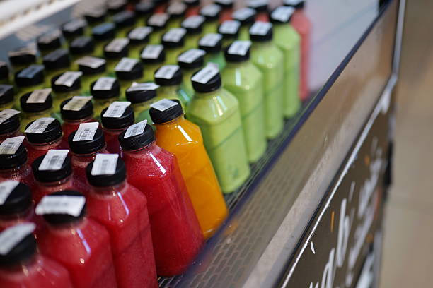 Fresh bottled juices on ice with apples in background
