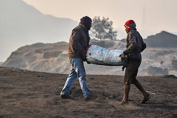 Two men carrying heavy sack in Dhanbad coal area