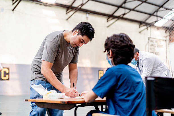 Mid adult man signing document at community center