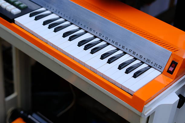 Bright red upright piano shot from the front, standing on light marble floor. Elegant pose, modern and vibrant design.