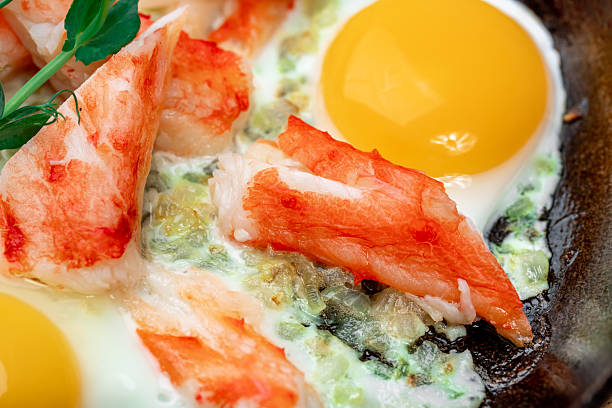 Hearty Fried Eggs with Crab Meat and Tomatoes in a Cast Iron Skillet. very close-up
