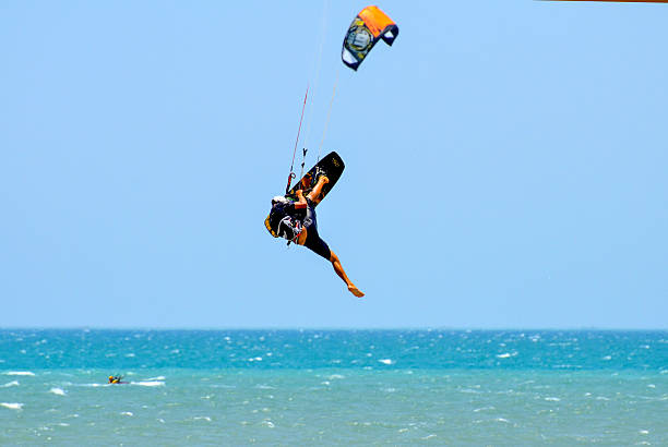 Hurghada, Egypt - July 16, 2015: A professional kitesurfer is launching into a spectacular jump, creating a large splash in the turquoise water. The image captures the peak of an exciting aerial stunt.