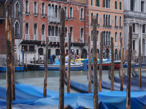 Gondolas docked and tied to poles at the harbour at Saint Marks in Venice, Italy.