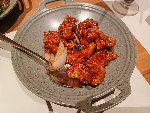 Sweet and spicy fried chicken bites with honey sauce on ceramic plate