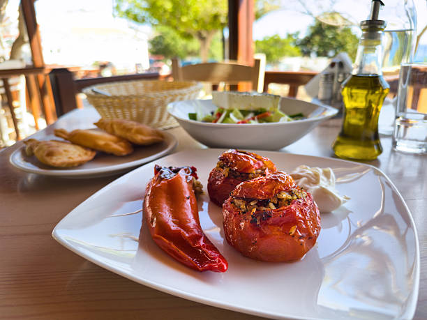 Stuffed Vegetables served in a seaside tavern. Spinach pies and greek salad in the background.