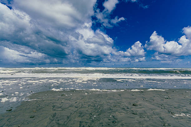 Foamy waves crash under towering clouds stormy cumulus seascape coast coastal
