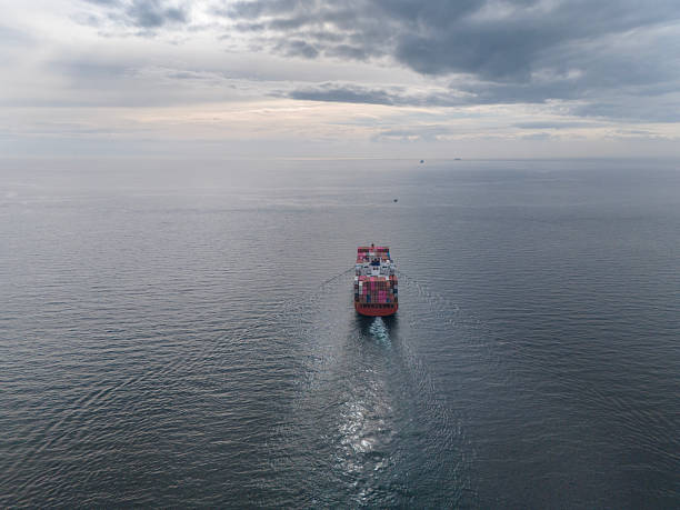 Aerial back view of large cargo container ship in transit.