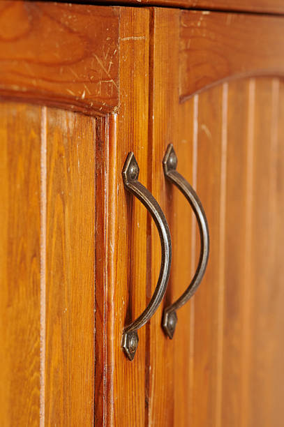 Close up view of old wooden cabinet doors featuring antique style metal handles