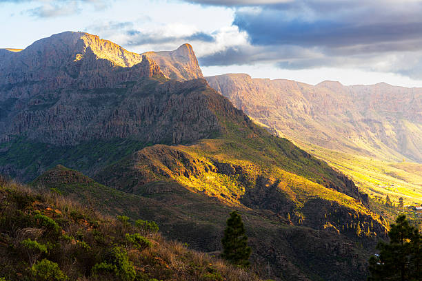 Warm light illuminates rugged rocky slopes of the stony mountains at sunset, Gran Canaria, Canary Islands, Atlantic Ocean, Spain