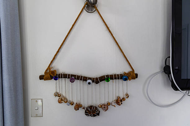 Decorative craft piece hangs beside curtain screen decor coastal beachy