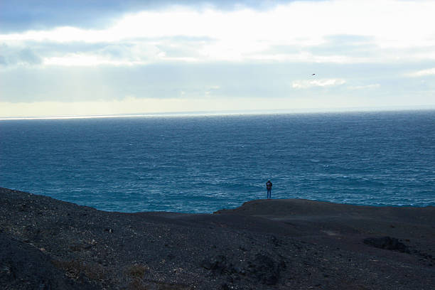 Back view of a man praying with his hands open in the sky
