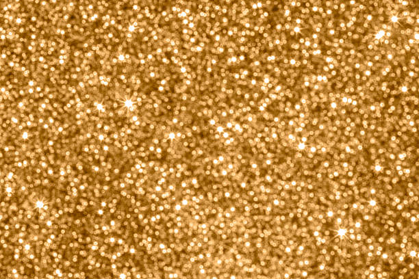 Golden glittery background with warm, sparkling bokeh ideal for festive, luxury, or celebratory designs.