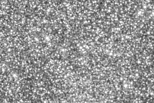 A glittery silver background with countless small light spots creating a festive, luxurious mood.