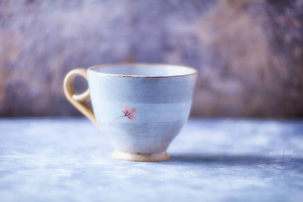 Yellow polka dot teacup and saucer on a table.