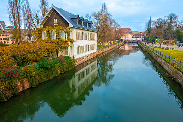 Strasbourg, France - December 5, 2025: Beautiful travel landscape with half-timbered houses on the banks of the river ill and decorated flowers in Strasbourg. France quarter in Strasbourg.